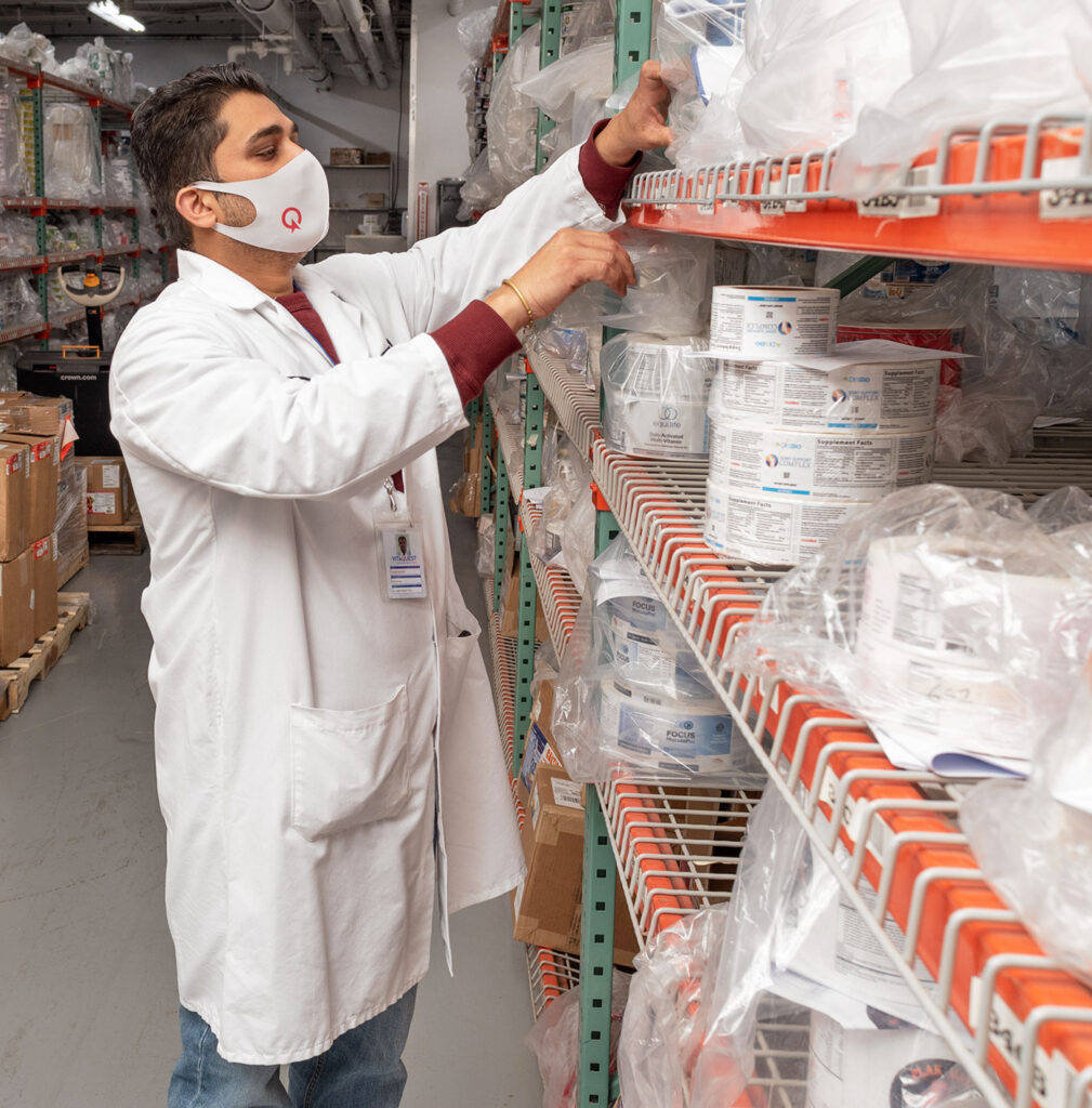 Vitaquest warehouse tech inspecting supplement packaging labels Vitaquest warehouse tech inspecting supplement packaging labels